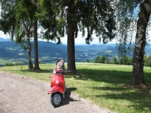 Rote Vespa auf Rollertour durch Österreich mit Blick auf das Drautal