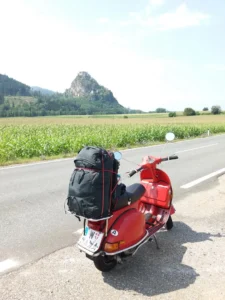 Rote Vespa auf Rollertour durch Österreich vor Burg Hochosterwitz