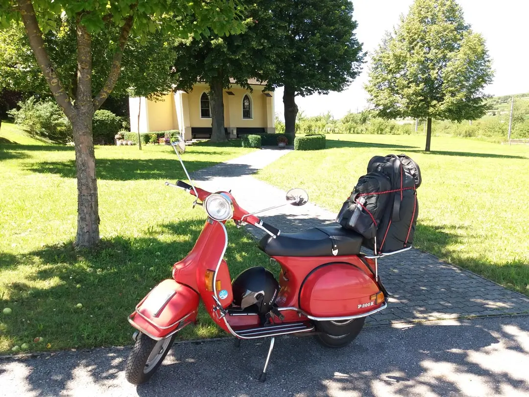 Rote Vespa auf Rollertour bei einer Kapelle in Niederösterreich - Vespatouren durch Österreich